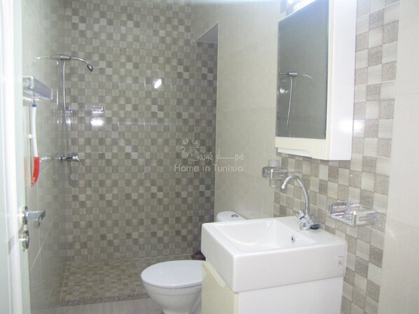 Un bagno con doccia, WC e lavandino.