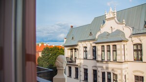 A multi-story building with ornate architectural details, including a balcony with a bust sculpture. - Miedziany (Torun)