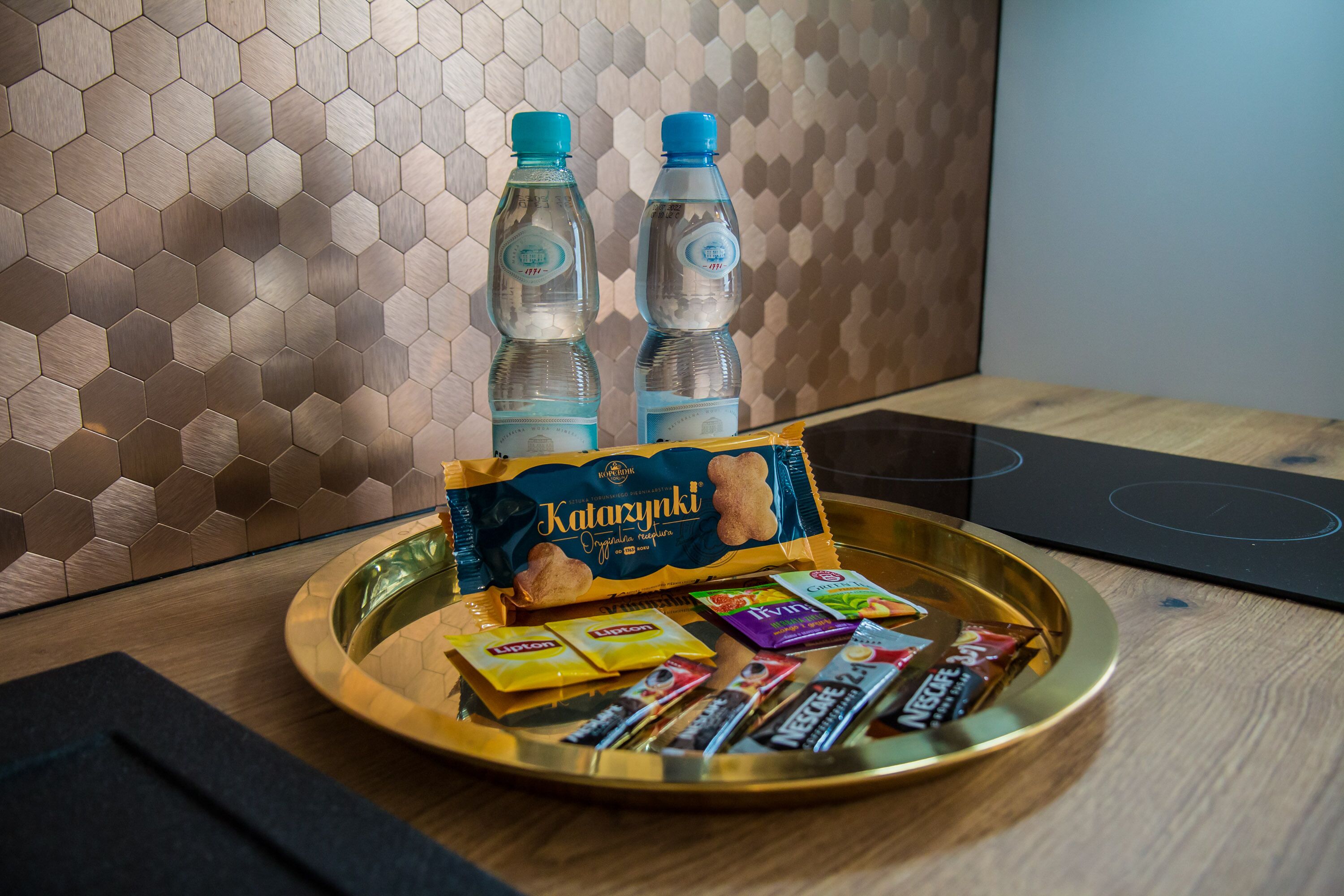 A tray with snacks and bottled water on a wooden table.