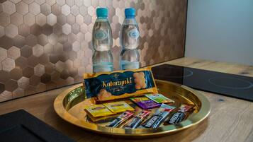 A tray with snacks and bottled water on a wooden table.