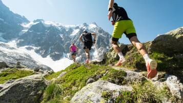 A mountainous hiking trail with rocky terrain and a clear sky.