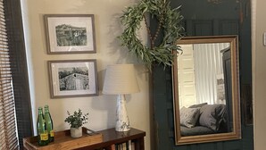 Una stanza con un tavolino in legno, uno specchio, una panca e una porta decorata con un'asse di Natale.