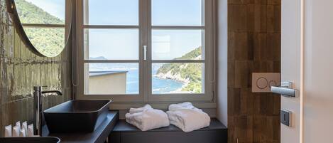 Un baño con una ventana grande, un lavamanos y una bañera.