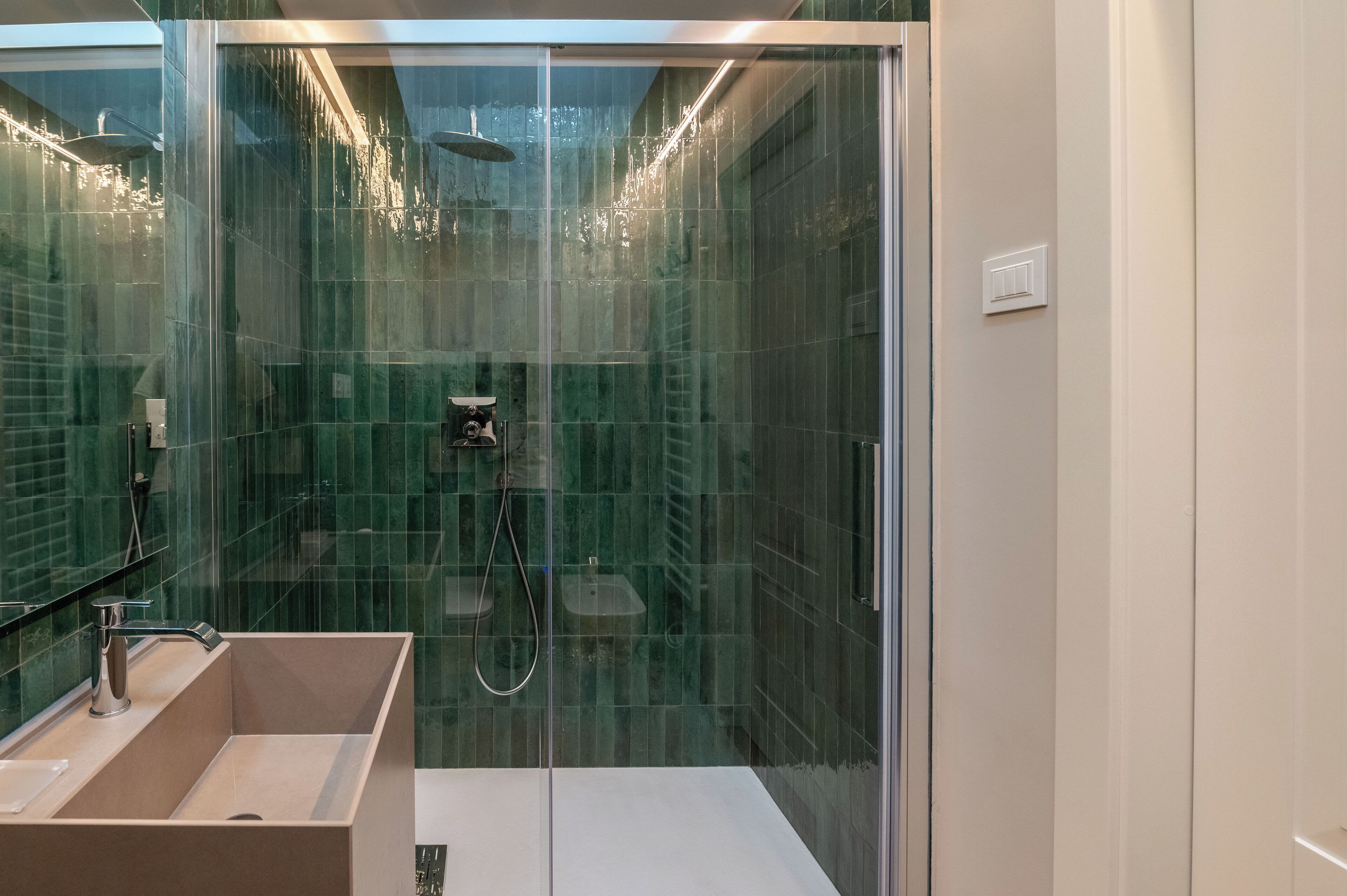 Un baño moderno con cabina de ducha de vidrio, un lavabo y un inodoro.