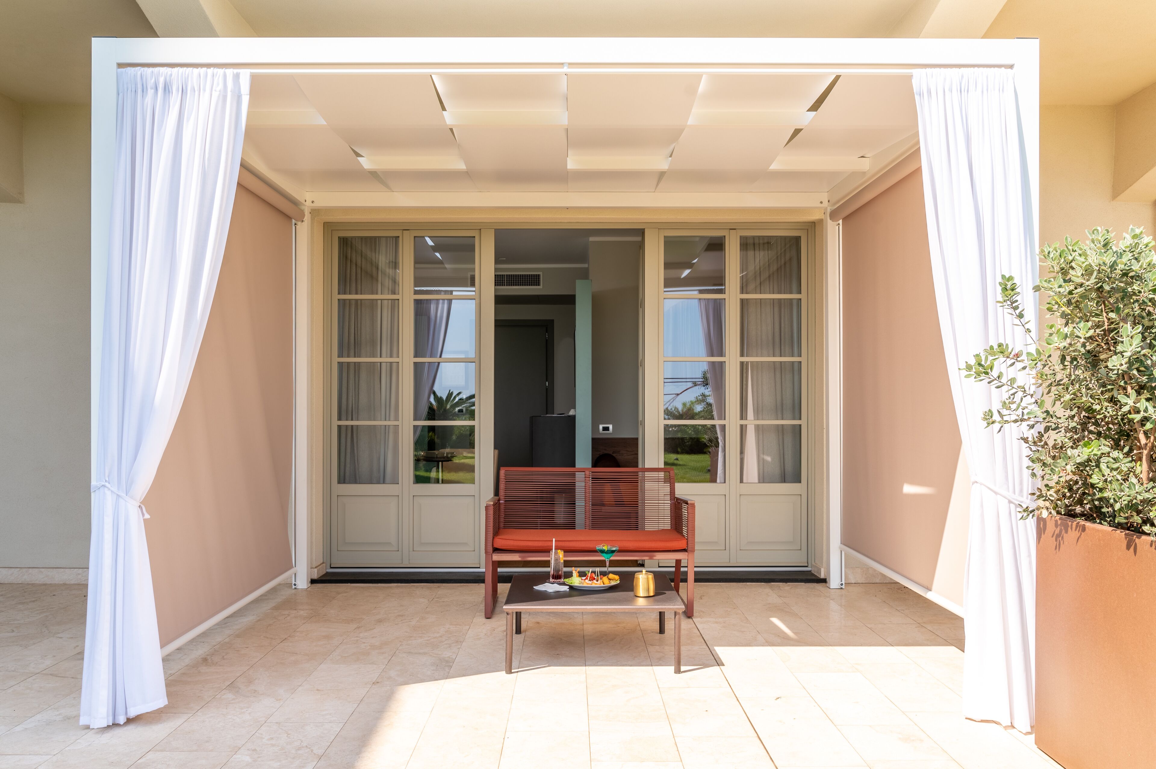A room with a sliding glass door, a wooden bench, and a small table with a tray of food.