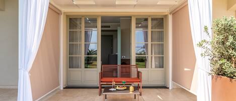 A room with a sliding glass door, a wooden bench, and a small table with a tray of food.