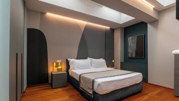 A modern bedroom with a bed, bedside tables, and a skylight.