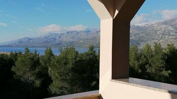 Un balcon avec vue sur un lac et des montagnes.