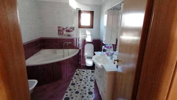 Ein Badezimmer mit Badewanne, Toilette und Waschbecken.