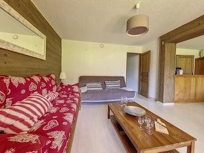 A living room with a red sofa, a grey sofa, a wooden coffee table with glasses, and a wooden cabinet in the background. - 200m from resort center, 1st floor, view mountain, balcony, tv, ski locker, 66m² (Saint-Martin-de-Belleville)