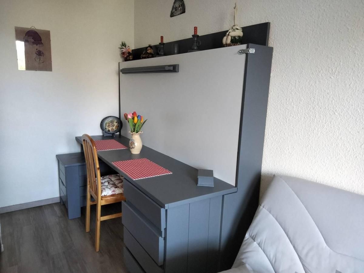 A compact room with a desk, chair, and a bed.