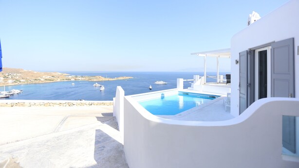 A white building with a pool and a view of the sea. - Grand Panoramic Villa Ozar (Mykonos)