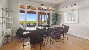 A dining area with a large island, bar stools, and a view of the outdoors. - Seasonal, Monthly, Annual (Marco Island)