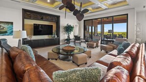 A spacious living room with leather sofas, a glass coffee table, and a large flat-screen TV. - Seasonal, Monthly, Annual (Marco Island)