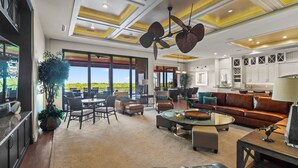 A spacious living area with a large window, a ceiling fan, and a view of the outdoors. - Seasonal, Monthly, Annual (Marco Island)
