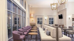 A hotel lobby with a long sofa, multiple chairs, a bar area, and large windows. - Homewood Suites by Hilton Broomfield Boulder (Broomfield)