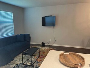 Relax in this stylish living room with a sofa, flat-screen TV, and coffee table.