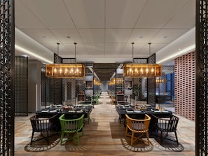 A modern dining area with multiple tables and chairs, decorative lighting, and a patterned floor. - DoubleTree by Hilton Quzhou (Quzhou)