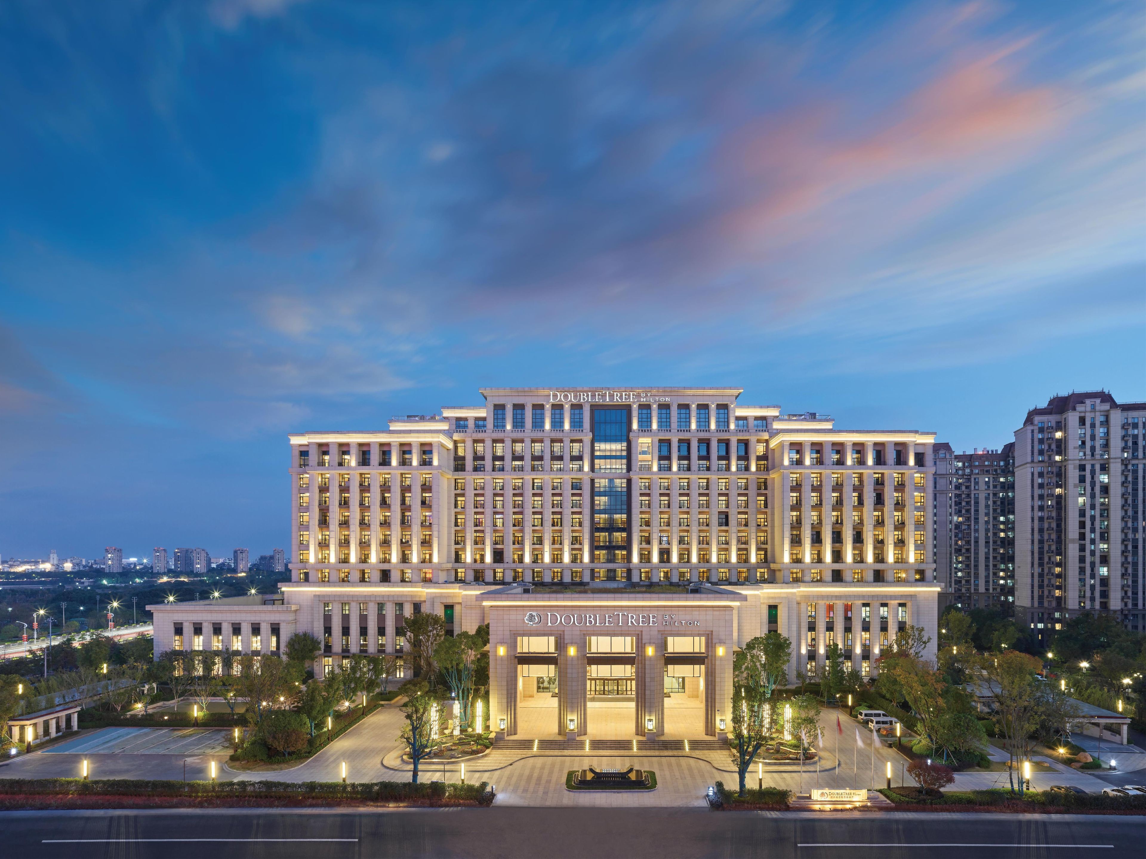 A large, multi-story hotel with a prominent entrance and a well-lit facade.