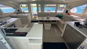 Ein kleines Boot Innenausstattung mit Essbereich, Küchenzeile und Sitzgelegenheiten.