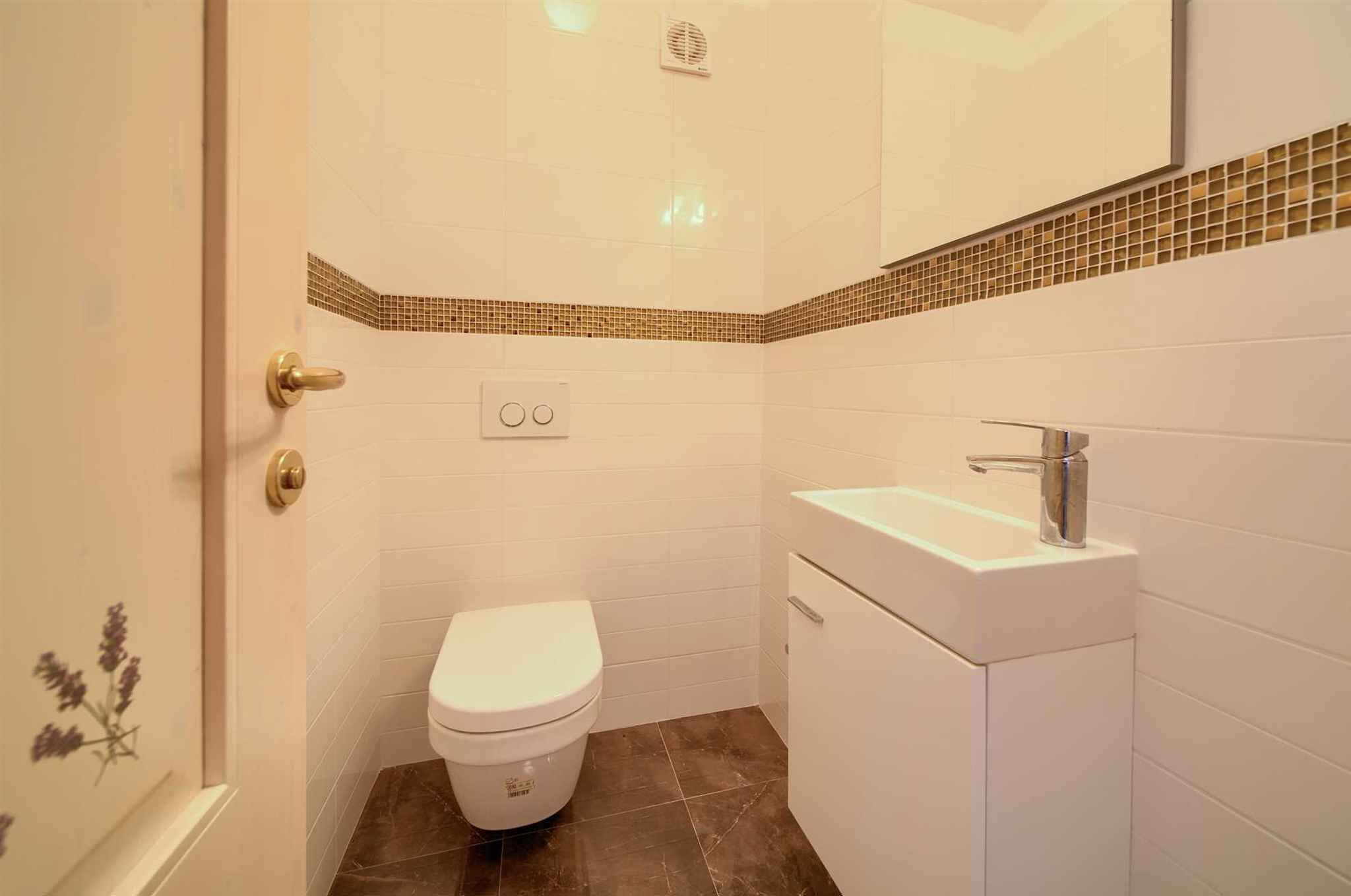 Une salle de bain avec des toilettes, un lavabo et un miroir.