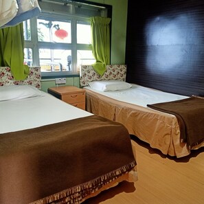 A hotel room with two beds, a window with curtains, a radiator, and a wooden headboard. - OYO 90366 Home Valley Guesthouse Tambunan (Tambunan)