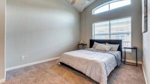 A bedroom with a bed, a ceiling fan, a window with blinds, and a carpeted floor. - Gorgeous downtown loft  (Dallas)