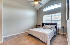 Cozy retreat with a single bed, ceiling fan, and window with blinds.