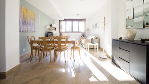 Amplia sala de estar con una mesa de comedor y sillas, un sofá, una mesa de centro y un mueble.