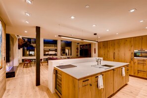 Een moderne keuken met houten kasten, een centraal eiland en ingebouwde apparatuur.