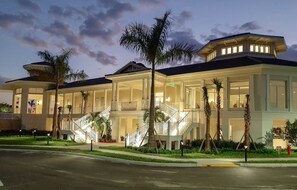 Classic hotel with a symmetrical facade and central entrance, set amidst palm trees.