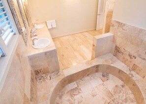 Une salle de bain avec une baignoire sur pieds, un lavabo et un miroir.