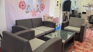 A room with wicker furniture, a glass coffee table, and a poster on the wall. - OYO Home 90370 D'tampi Homestay (Semporna)