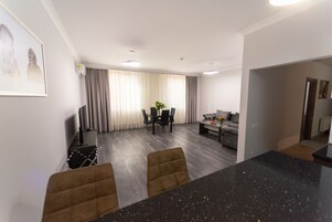 Een moderne woonkamer met een eethoek, een bank en een salontafel.
