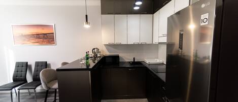 Una cocina moderna con una isla integrada, electrodomésticos de acero inoxidable y un diseño minimalista.