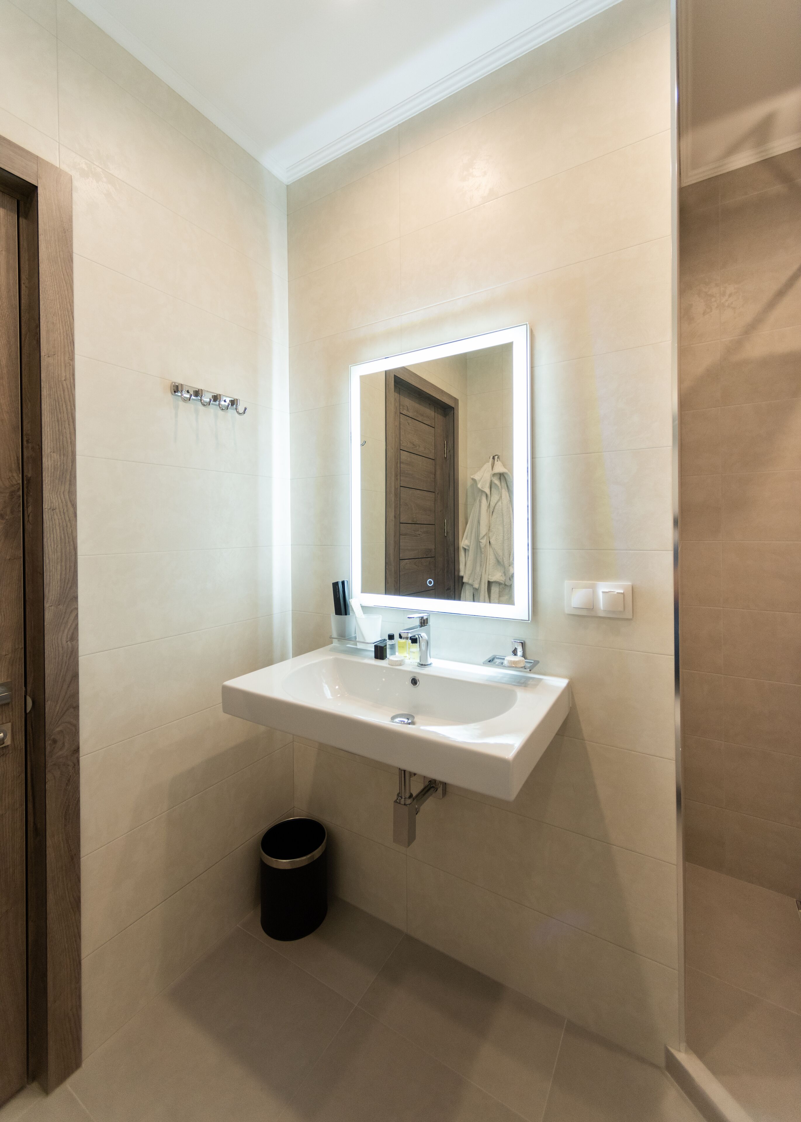 A bathroom with a white sink, a mirror, and a wooden door.