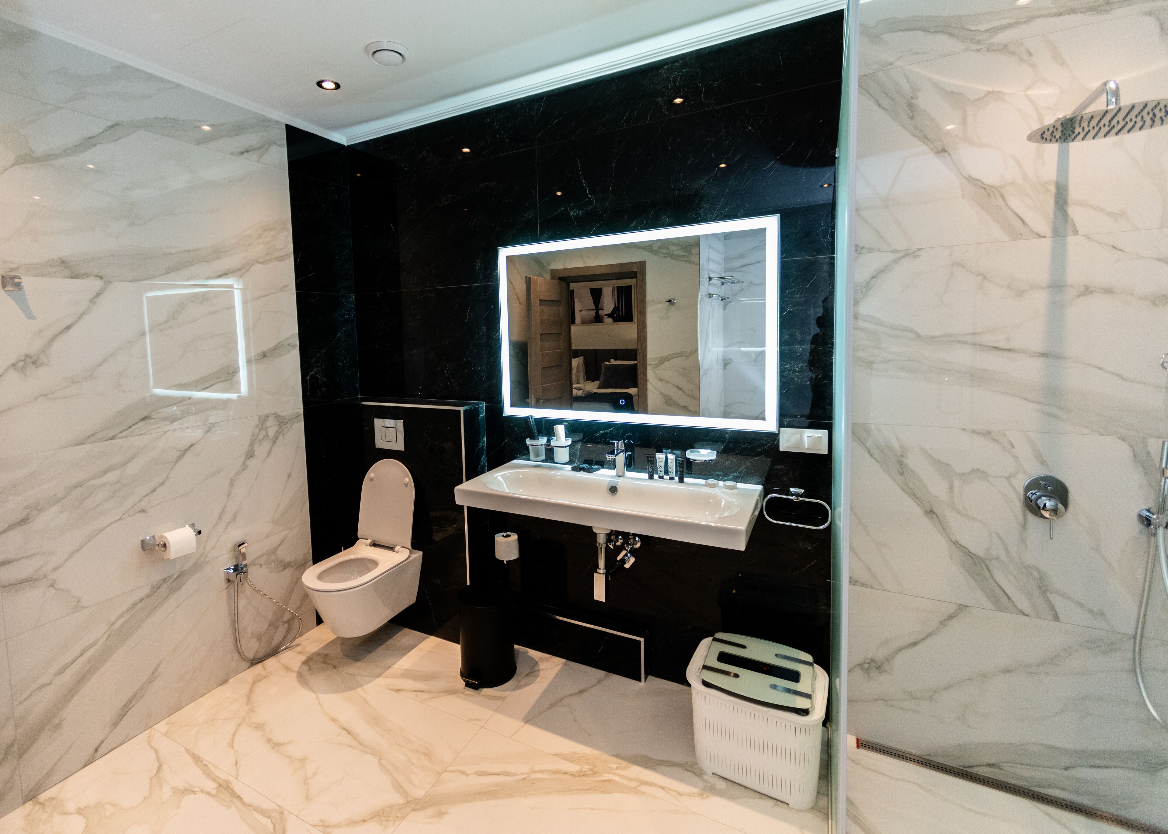 Un baño moderno con inodoro, lavamanos y ducha.