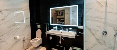Un baño moderno con inodoro, lavamanos y ducha.