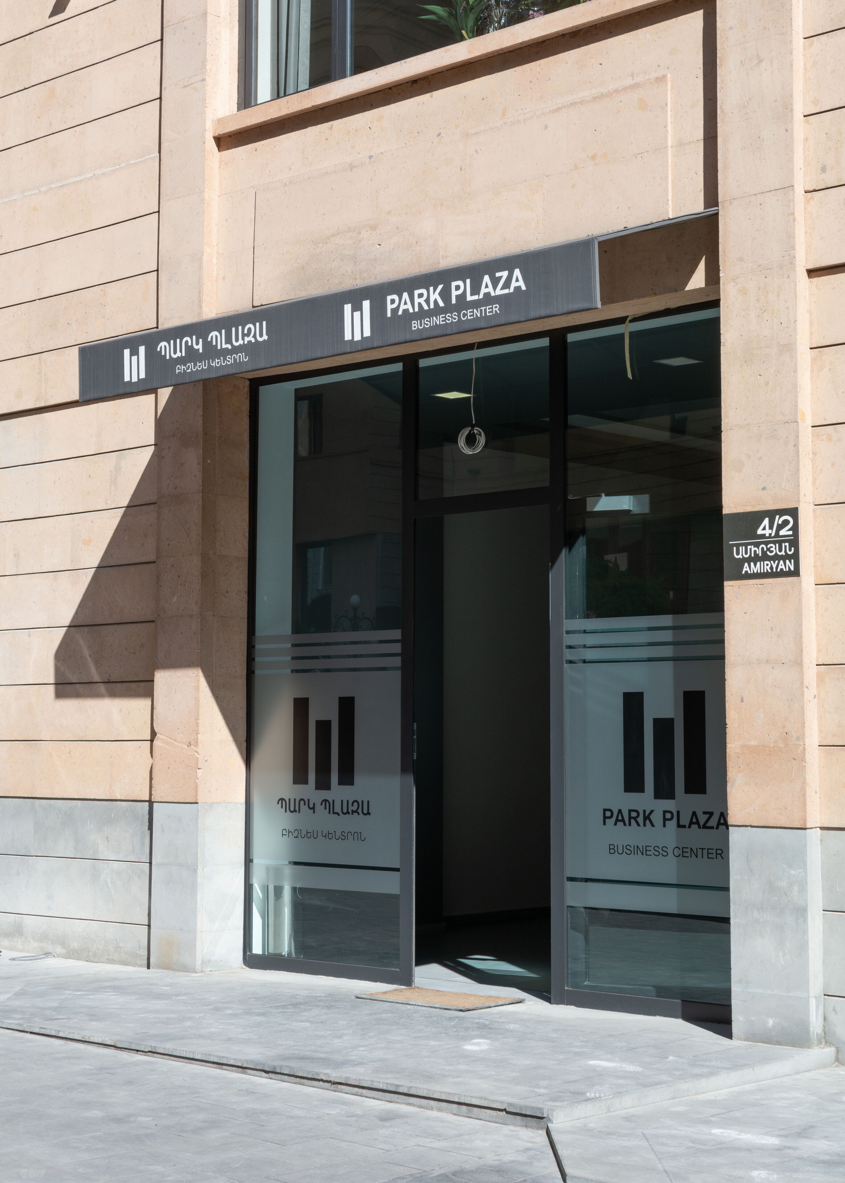 A building entrance with a sign reading "Park Plaza Business Center".