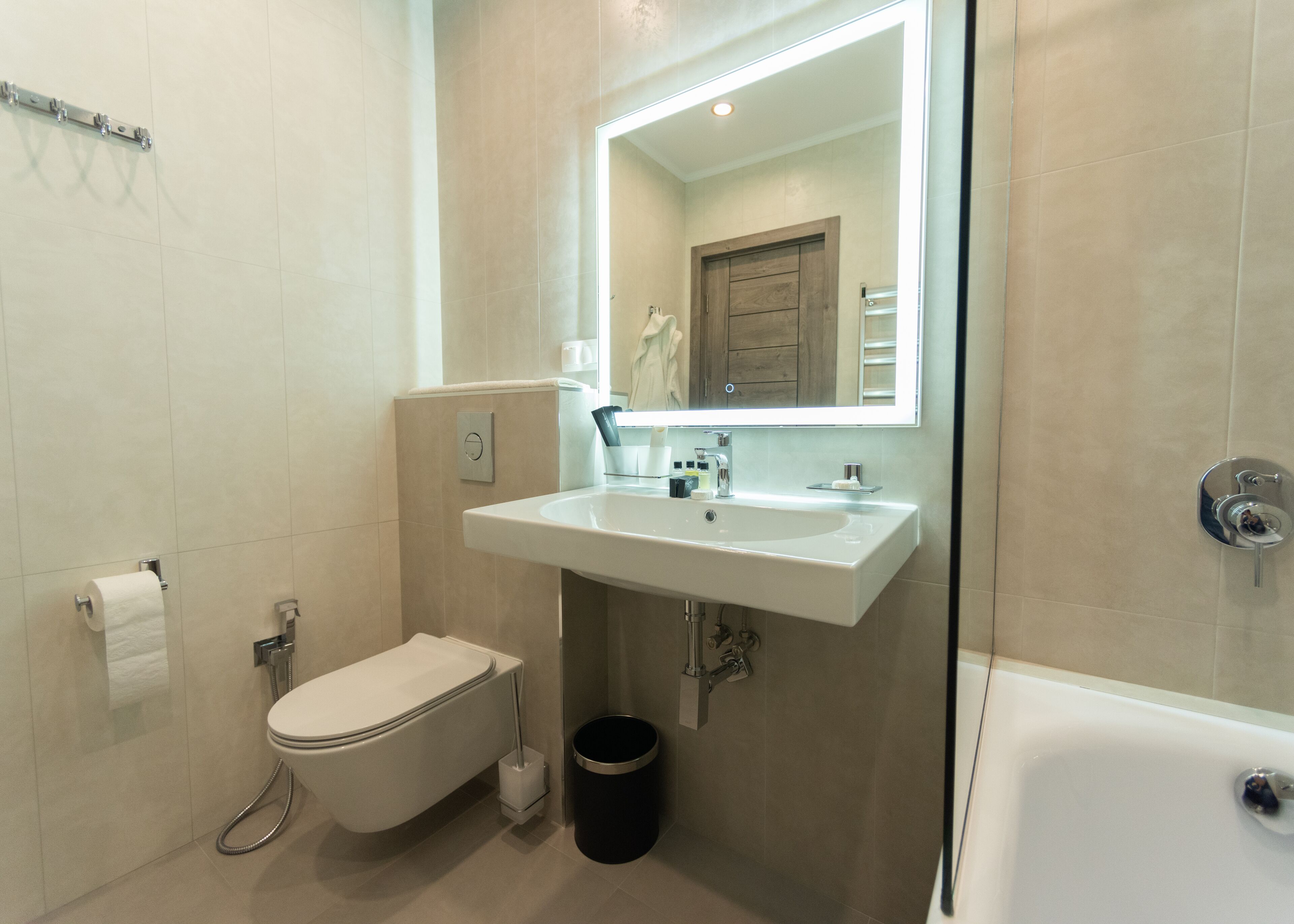 Een moderne badkamer met toilet, wastafel en bad.