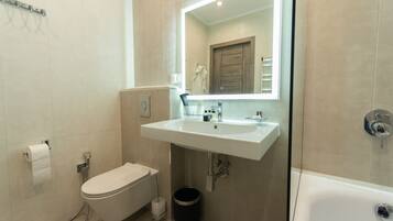 Een moderne badkamer met toilet, wastafel en bad.