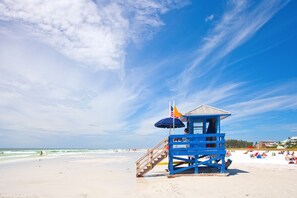 Une tour de surveillance des sauveteurs sur une plage, avec un ciel dégagé.
