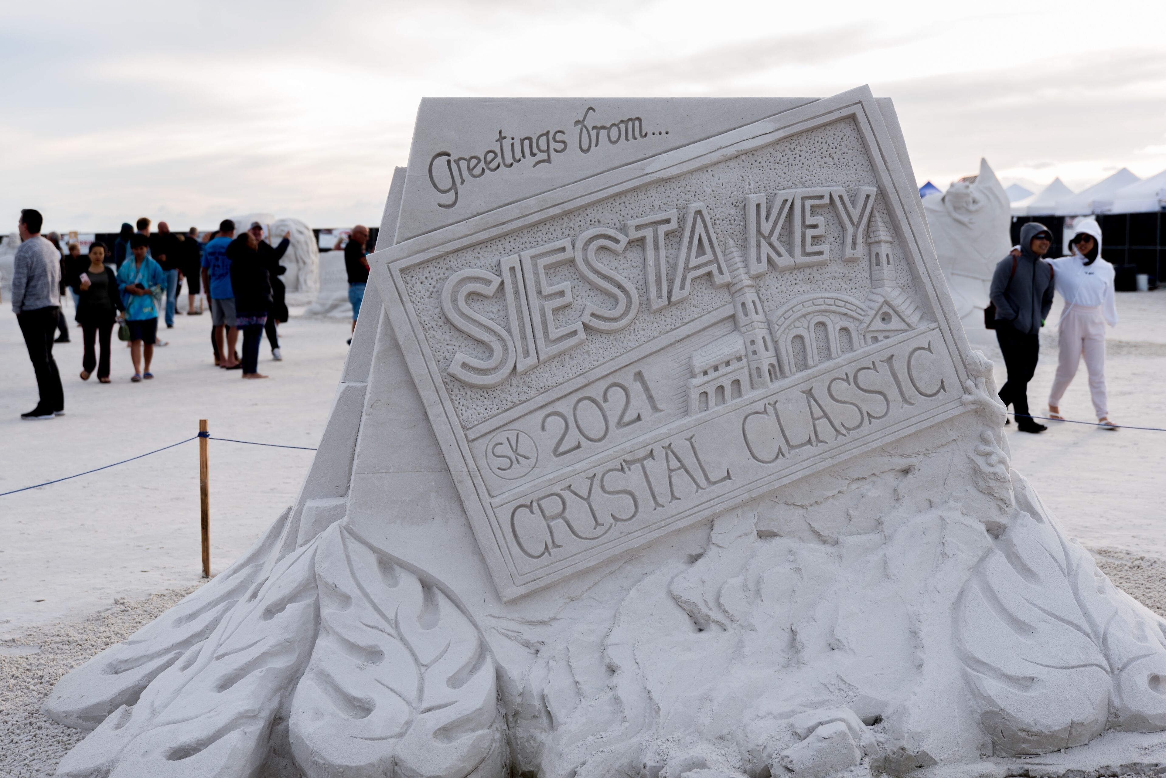 Une grande sculpture de sable, très détaillée, portant l’inscription : « Salutations de… Siesta Key 2021, Crystal Classic. »
