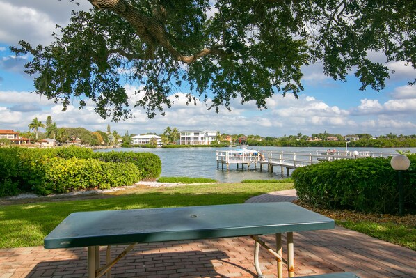 A riverside park with a dock, a table, and a bridge. - Siesta Key Condo- walk to beautiful beaches, ride a free trolley around the key (Sarasota)