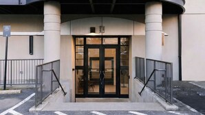 A hotel entrance with a curved overhang, double doors, and a sign indicating 'Dovetail.'
