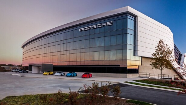 A modern building with a prominent Porsche logo, featuring a large parking area with several cars. - 724A · The Blue Bungalow - Min to Downtown and Airport! (Atlanta)