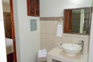 A bathroom with a sink, mirror, towel rack, and a small storage box. - Hostal Donde Regina (Guatemala City)