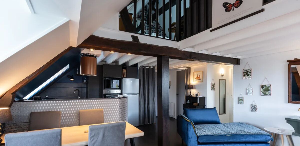 Un moderno spazio abitativo in stile loft con cucina, zona pranzo e un angolo salotto accogliente.