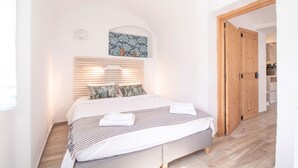 A bedroom with a bed, wooden door, and a small painting on the wall. - House Bella (Bohinjska Bela)