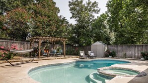 A backyard with a swimming pool, a wooden pergola, and a hammock. - Cozy 3 bdrm w/pool & hot tub!! (Oklahoma City)